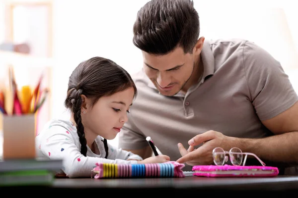 Hombre Ayudando Hija Con Tarea Mesa Interior — Foto de Stock