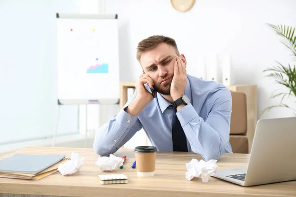 Lazy office employee talking on phone at workplace