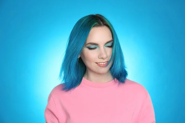 明るい青の背景に明るい染めの髪を持つ若い女性 — ストック写真