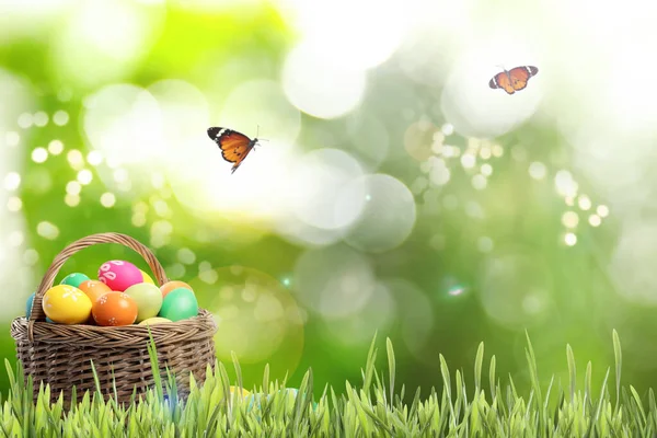 Fonott Kosár Húsvéti Tojással Zöld Fűben Pillangók Elmosódott Háttérrel Szöveges — Stock Fotó