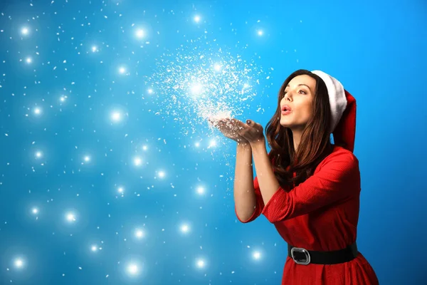 Hermosa Mujer Santa Sombrero Soplando Nieve Sobre Fondo Azul Claro —  Fotos de Stock