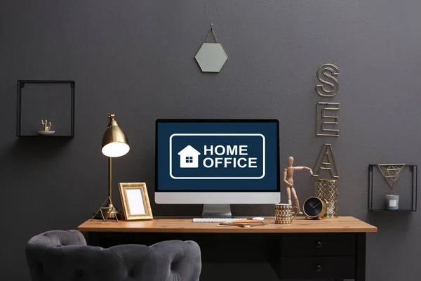 Modern computer with text HOME OFFICE on table indoors
