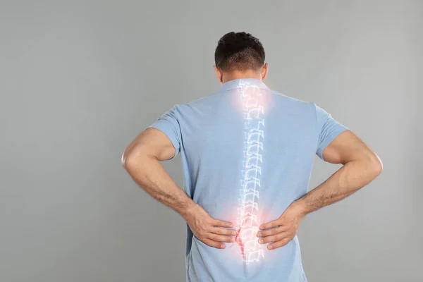 Homem Que Sofre Dor Coluna Vertebral Fundo Cinza — Fotografia de Stock