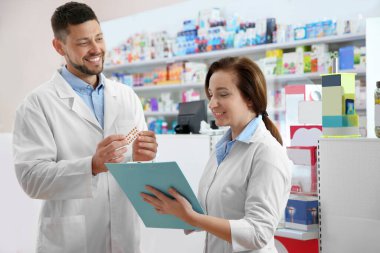 Portrait of professional pharmacists in modern drugstore clipart