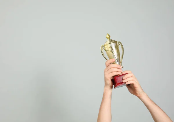 Hombre Sosteniendo Copa Trofeo Oro Sobre Fondo Gris Claro Primer — Foto de Stock