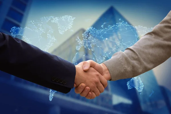 Closeup view of partners shaking hands and world map. Business values
