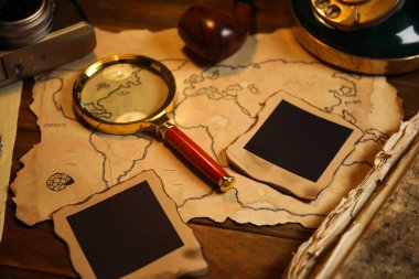 Ahşap masanın üzerinde klasik dedektif eşyalarıyla kompozisyon, yakın plan.