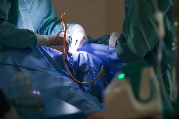 Professional doctors performing operation in surgery room, closeup