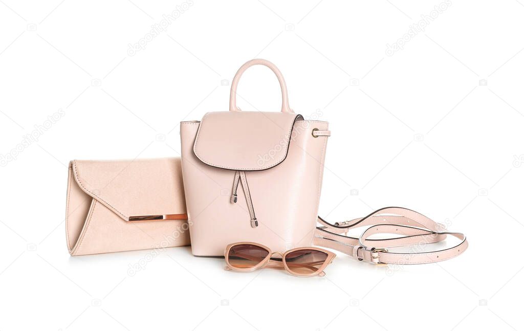 Different stylish woman's bags and sunglasses isolated on white