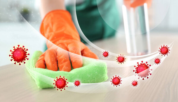 Cleaning vs viruses. Woman washing table with sponge and disinfecting solution
