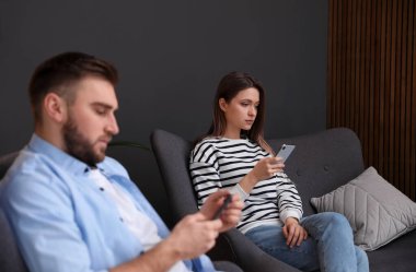 Evde birbirini görmezden gelen akıllı telefonlara bağımlı bir çift. İlişki sorunları