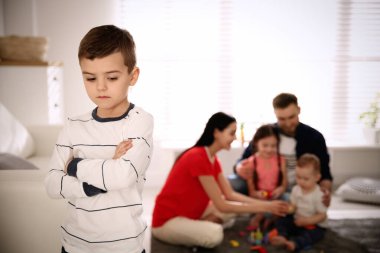 Mutsuz küçük çocuk, ebeveynler diğer çocuklarla evde vakit geçirirken kıskançlık hissediyor.