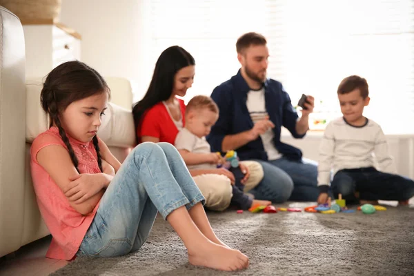 Ebeveynler diğer çocuklarla evde vakit geçirirken mutsuz küçük kız kıskançlık hissediyor.