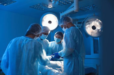 Profesyonel doktorlardan oluşan bir ekip ameliyathanede ameliyat yapıyor.