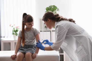 Klinikte suçiçeği aşısı olan küçük bir kız. Varicella virüs önleme