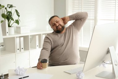 İş yerinde tembellik eden aşırı kilolu ofis çalışanı.