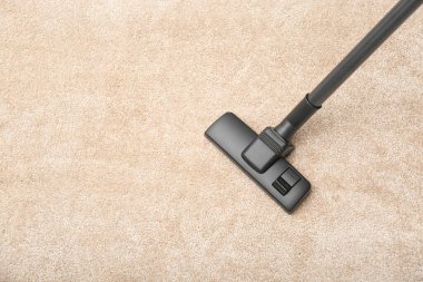 Modern elektrikli süpürgeyle halıdaki toprağı kaldırmak, üst manzara. Metin için boşluk