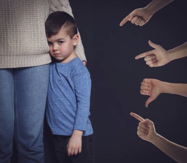 İnsanlar siyah arka planda küçük çocuğa zorbalık yapıyor.