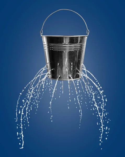 Leaky bucket with water on blue background