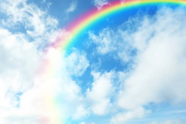 Güneşli bir günde güzel gökkuşağının ve mavi gökyüzünün manzarası. 