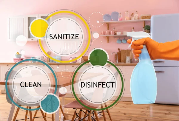 Keep your home virus-free. Woman cleaning kitchen with disinfecting solution