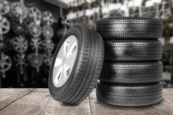 自動車店の灰色の木製の表面の車のタイヤ — ストック写真