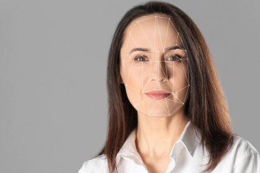 Yüz tanıma sistemi. Gri arka planda biyometrik tanımlama ızgarası olan olgun bir kadın
