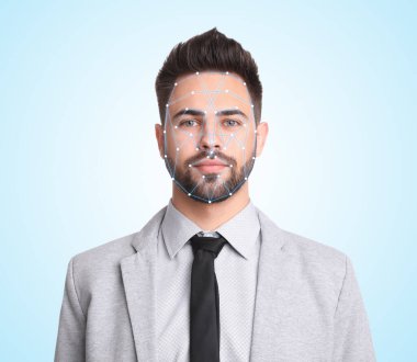 Yüz tanıma sistemi. Biyometrik tanımlama sistemine sahip genç adam ışık arka planında tarama yapıyor.