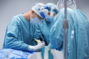 Profesyonel doktorlardan oluşan bir ekip ameliyathanede ameliyat yapıyor.