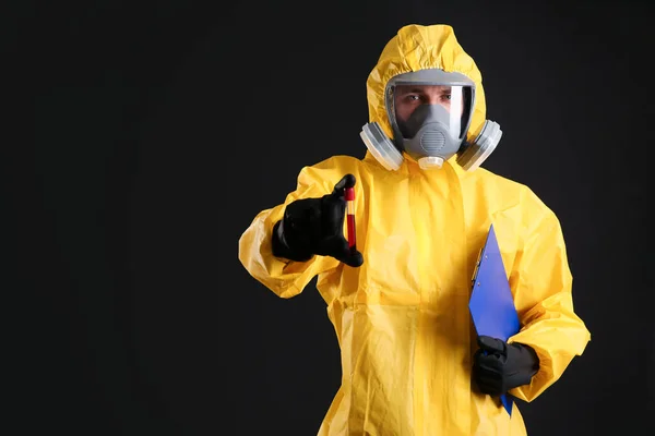 身穿化学防护服的男子拿着黑底血样试管 空白处有文字 病毒研究 — 图库照片