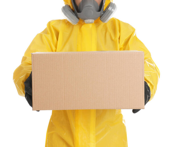 Man wearing chemical protective suit with cardboard box on white background, closeup. Prevention of virus spread