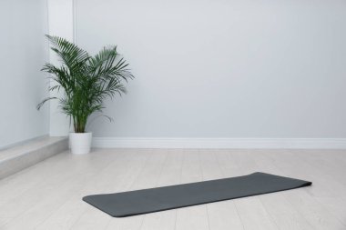 Odanın zemininde siyah yoga minderi açık. Metin için boşluk