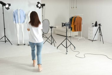 Profesyonel fotoğrafçı fotoğraf stüdyosunda modern kıyafetlerle hayalet mankenlerin fotoğrafını çekiyor.