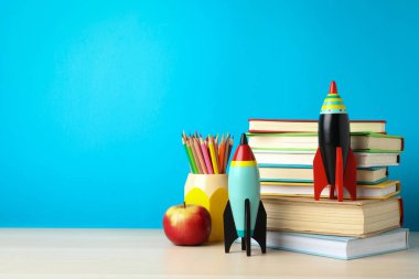 Parlak oyuncak roketler ve okul malzemeleri ahşap masada. Metin için boşluk