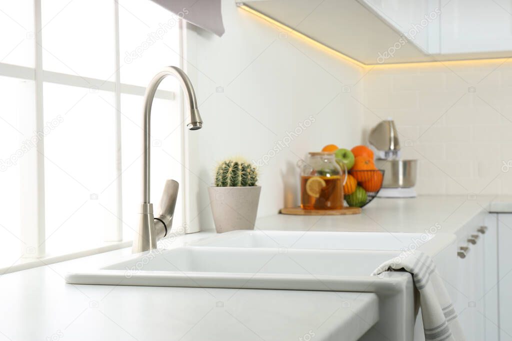 Ceramic sink and modern tap in stylish kitchen interior