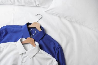 Beyaz kumaşlı şık gömlekler, yakın plan. Kuru temizleme servisi.