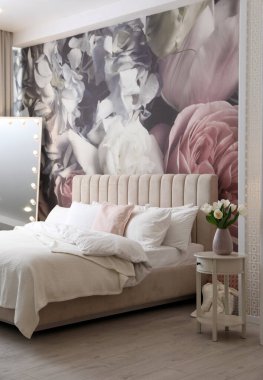 Büyük yataklı, aynalı ve çiçek desenli güzel bir oda.