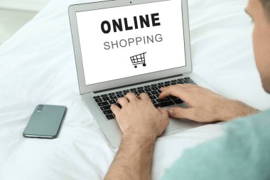 Karantina sırasında modern dizüstü bilgisayarı online alışveriş için kullanan adam, yakın plan. Teslimat servisi
