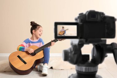 Küçük müzik öğretmeni içeride gitar dersi kaydediyormuş.