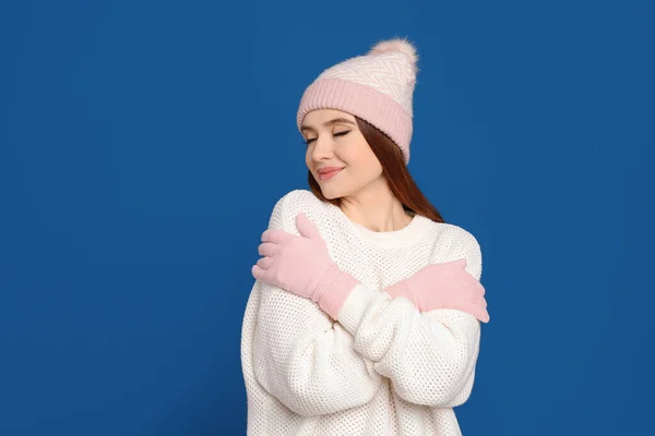 暖かいセーター 帽子を青い背景に身に着けている若い女性 冬の季節 — ストック写真