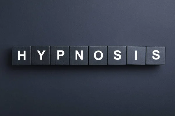 黒い背景に単語Hypnosisと木製のブロック フラットレイアウト — ストック写真