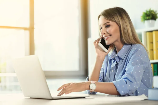 Молодая Женщина Разговаривает Телефону Время Работы Ноутбуком Столом Офисе — стоковое фото