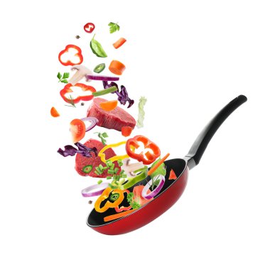 Farklı sebzeler ve sığır dilimleri beyaz arka planda kızartma tavasına düşüyor. Yemek pişirme süreci