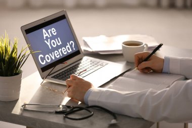 Doktor ve laptopta mesaj var. Hallettin mi? Ekranda kapalı, yakın çekim. Sigorta konsepti