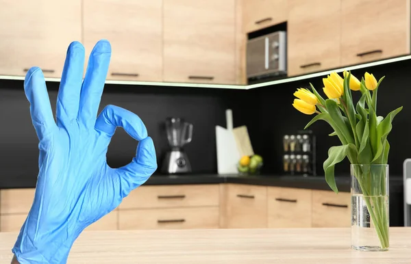 Keep your home virus-free. Woman showing Ok in clean kitchen