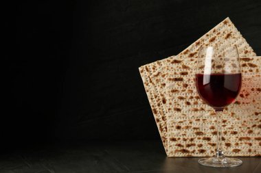 Hamursuz Bayramı matzoları ve siyah arka planda bir bardak şarap, yazı için yer. Pesach kutlaması