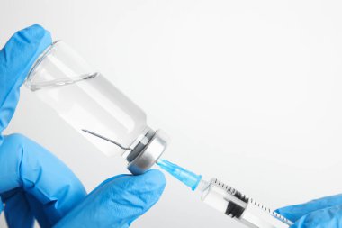 Şırıngayı beyaz arka planda ilaçla dolduran doktor, yakın plan. Aşılama ve aşılama