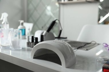 Güzellik salonundaki masada profesyonel manikür malzemeleri var.