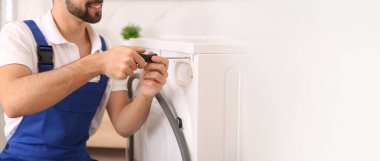 Profesyonel tesisatçı banyoda çamaşır makinesini tamir ediyor, mesaj için yer var. Pankart tasarımı