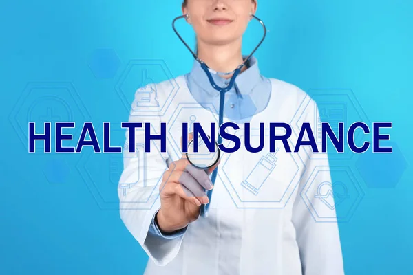 短语健康保险 图标和医生与听诊器蓝色背景 — 图库照片